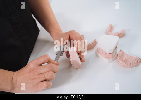 Dentiste la mesure de l'impression de dents en plâtre. Moule en plâtre dentaire. Dentaire moule montrant les dents sur une table face affichée sur la dentisterie dans une hygiène orale Banque D'Images