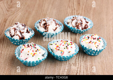 Cupcakes crémeux sur fond de bois Banque D'Images