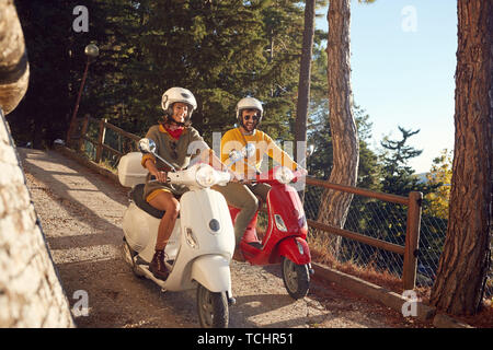 Jeune femme gaie et les hommes de la trottinette et à la recherche à l'Italie en vacances Banque D'Images