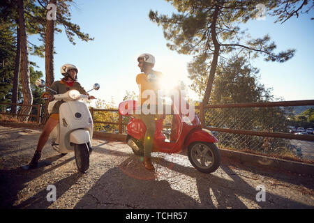 Cheerful young woman and man voyageant sur la moto et à la recherche à l'Italie en vacances Banque D'Images