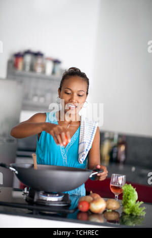 Femme au foyer asiatique de préparer des aliments et comprime la tomate dans meal Banque D'Images