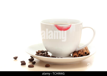 Tasse de café avec le rouge à lèvres mark les haricots et les bâtons de cannelle isolated on white Banque D'Images