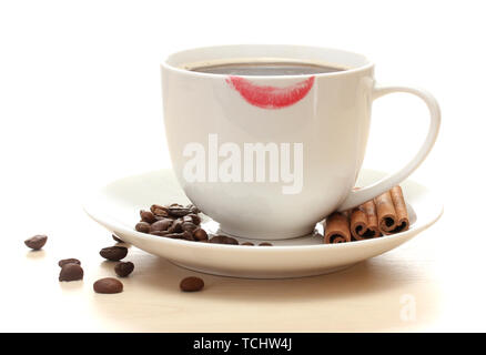 Tasse de café avec le rouge à lèvres mark les haricots et les bâtons de cannelle isolated on white Banque D'Images