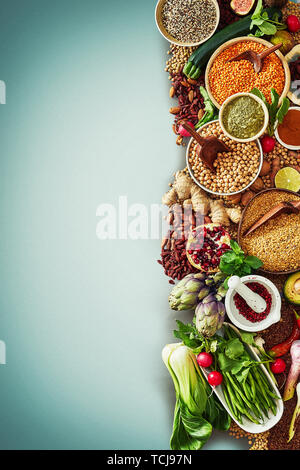 Grand choix de légumes frais, de fruits, de graines et d'épices dans un aliment conceptuel à la frontière d'une saine alimentation et la nutrition sur un fond bleu avec v Banque D'Images