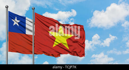 Le Chili et de brandir le drapeau du Vietnam dans le vent contre ciel bleu nuageux blanc ensemble. Concept de diplomatie, de relations internationales. Banque D'Images