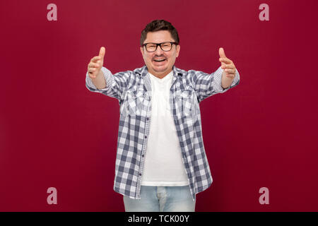 Portrait of happy heureux de voir handsome middle aged man in casual chemise à carreaux et des lunettes à pleines dents, sourire permanent et souhaitez hugging Banque D'Images
