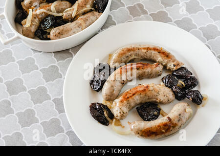Saucisse blanche avec des oignons frits et les prunes séchées. Banque D'Images