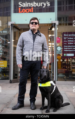 Ski alpin paralympique britannique John Dickinson-Lilley avec son chien-guide, Brett, l'extérieur du magasin Sainsbury's sur Southampton Row à Holborn, centre de Londres, à quelques minutes de la chaîne de supermarchés a son siège social, où il a été deux fois refusé l'entrée avec son chien. Banque D'Images