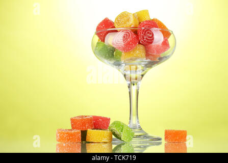 Dans les bonbons jelly dans verre à cocktail sur fond vert Banque D'Images