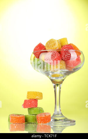 Dans les bonbons jelly dans verre à cocktail sur fond vert Banque D'Images