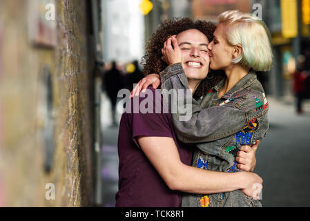 Jeune femme s'embrasser son petit ami dans l'arrière-plan urbain typiquement sur une rue de Londres