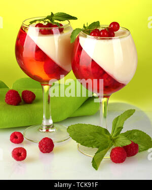 Fruit jelly aux fruits rouges dans les verres sur fond vert Banque D'Images