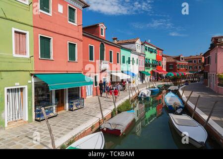 Bateaux amarrés sur canal bordé de maisons colorées, de boutiques et de touristes, l'île de Burano, lagune de Venise, Venise, Vénétie, Italie Banque D'Images