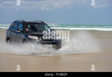 Hyundai Santa Fe Noir 4x4 hors route véhicule roule sur la plage de sable de quatre-vingt-dix Mile Beach dans l'eau, loin du Nord District, Northland, île du Nord Banque D'Images