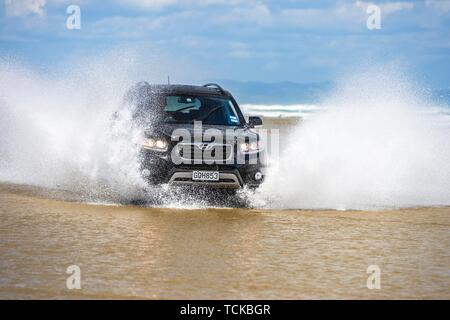 Hyundai Santa Fe Noir 4x4 SUV lecteurs sur la plage de 90 Mile Beach dans l'eau, loin du Nord District, Northland, North Island, New Zealand Banque D'Images