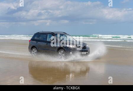 Hyundai Santa Fe Noir 4x4 hors route véhicule roule sur la plage de sable de quatre-vingt-dix Mile Beach dans l'eau, loin du Nord District, Northland, île du Nord Banque D'Images