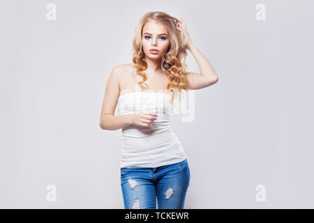 Belle blonde woman standing against white wall background Banque D'Images