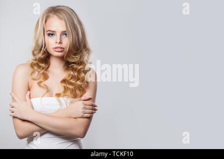 Jeune femme blonde parfaite avec les cheveux bouclés sur blanc Banque D'Images
