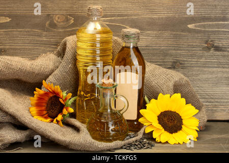 En bouteilles d'huile, de tournesol et de graines, sur fond de bois Banque D'Images