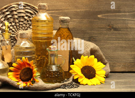 En bouteilles d'huile, de tournesol et de graines, sur fond de bois Banque D'Images