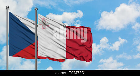 République tchèque et de Malte drapeaux dans le vent contre ciel bleu nuageux blanc ensemble. Concept de diplomatie, de relations internationales. Banque D'Images