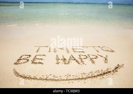 Close-up de temps d'être heureux et sourire texte écrit sur Sand At Beach Banque D'Images