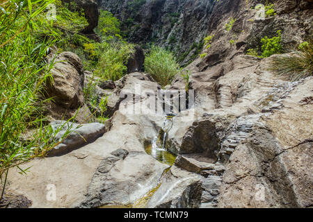 Les roches dans la gorge de Masca, Tenerife, montrant des couches de lave volcanique solidifiée et arc de cercle. Le ravin ou barranco mène à l'océan fr Banque D'Images