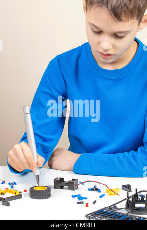 Voiture robot Boy making. La technologie robotique, l'apprentissage, l'éducation, de la tige pour les enfants contexte Banque D'Images