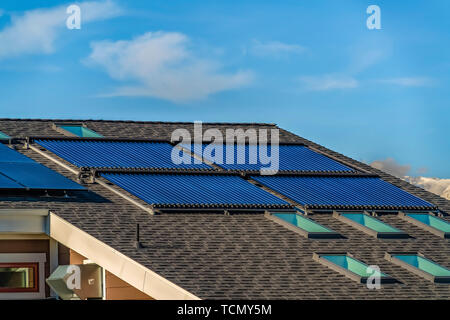 Toit en pente avec chauffe-eau solaire panneaux solaires et puits Banque D'Images