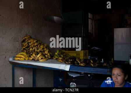 Caracas, Venezuela. 8 juin, 2019. Petare est le plus grand bidonville de Caracas au Venezuela. Une femme est assise près de plantains qui sont à vendre au cours d'une perte d'électricité. Credit : Allison Dîner/ZUMA/Alamy Fil Live News Banque D'Images