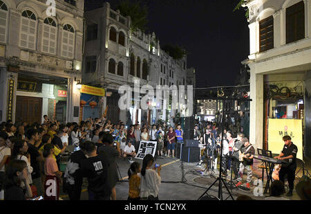 Haikou, province de Hainan en Chine. 8 juin, 2019. Les touristes regarder une exécution musicale à Qilou street à Haikou, capitale de la province de Hainan en Chine du sud, le 8 juin 2019. Crédit : Yang Guanyu/Xinhua/Alamy Live News Banque D'Images