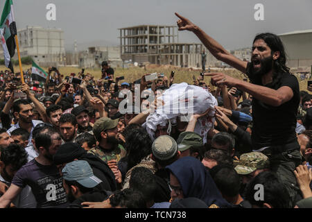 Annonce Dana, la Syrie. 09Th Juin, 2019. Les gens portent le corps de al-Abdel-Baset Sarout, un homme de 27 ans gardien syrien qui a rejoint la rébellion armée contre le président Bachar al-Assad, lors de ses funérailles après sa mort le samedi des blessures reçues lors de la bataille contre al-Assad·s forces dans la campagne de la province de Hama. L'ex-gardien de la Syrie·s de l'équipe junior a été parmi les premiers athlètes qui rejoint l'anti-al-Assad révolte quand il a éclaté en 2011. Credit : Anas Alkharboutli/dpa/Alamy Live News Banque D'Images