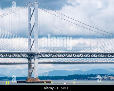 South Queensferry, Ecosse, Royaume-Uni, 9 juin 2019 UK Weather : dramatique de la lumière et des nuages sombres se rassemblent sur le Forth Road Bridge et le croisement avec Queensferry dériveurs jaune vif créant un contraste de couleur et de taille stark dans le Forth Banque D'Images