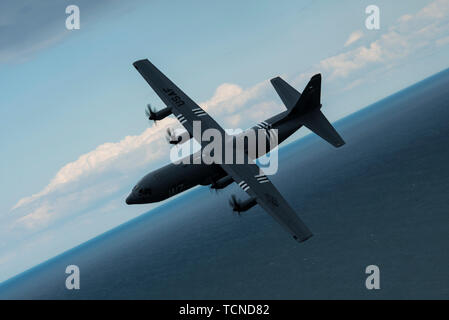 Un U.S. Air Force C-130J Super Hercules, affecté à la 37e Escadron de transport aérien, la base aérienne de Ramstein, Allemagne, porte les marques de whisky "7", parce qu'elle vole au-dessus de l'Utah Beach, Normandie, France, 6 juin 2019. Whiskey 7 est l'identificateur de l'escadron pour le 37e Escadron de transport de troupes, le 37e Escadron des chasseurs comme. (U.S. Photo de l'Armée de l'air par la Haute Airman Devin M. Rumbaugh) Banque D'Images