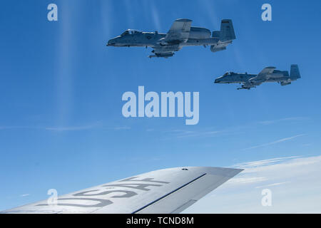 Deux A-10 Thunderbolt II aéronefs affectés à la 122e Escadre de chasse de la Garde nationale aérienne de l'Indiana, voler en formation avec un KC-135R Stratotanker "" affecté à la 171e Escadre de ravitaillement en vol, New York Air National Guard, 5 juin 2019. L'un A-10's généralement voler en formation avec le ravitaillement en vol jusqu'à ce que tous les avions de chasse ont été ravitaillé. (U.S. Photo de la Garde nationale aérienne par le sergent. Bryan Hoover) Banque D'Images