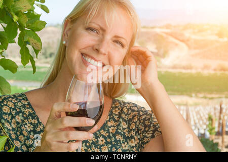 Belle Jeune femme adulte bénéficiant d'verre de dégustation de vin dans le vignoble. Banque D'Images