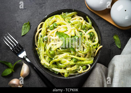 Les pâtes spaghetti à la courgette sur noir vue d'en haut. Banque D'Images