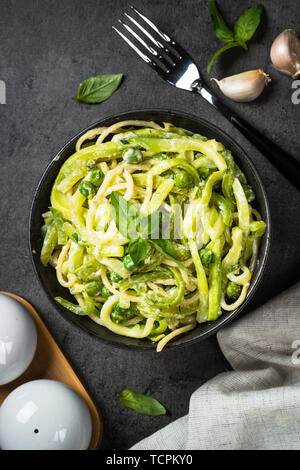 Les pâtes spaghetti à la courgette sur noir vue d'en haut. Banque D'Images