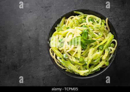 Les pâtes spaghetti à la courgette sur noir vue d'en haut. Banque D'Images