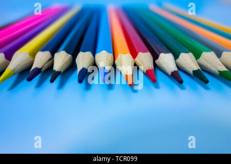 Un crayon de couleur sont soigneusement disposées dans un fond bleu