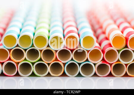 Paille papier à rayures de couleur sur fond blanc, close-up Banque D'Images