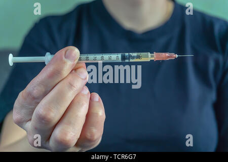 Jeune drogué avec une seringue dans sa main se fait une injection, injecte une drogue, l'injection d'insuline médicament urgent Banque D'Images