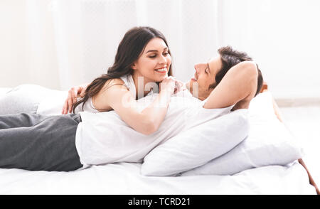 Loving couple relaxing in bed at home Banque D'Images