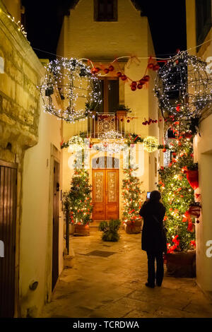 Fille prend une photo de la décoration de Noël alley in Bari dans la nuit. Région des Pouilles, Italie Banque D'Images