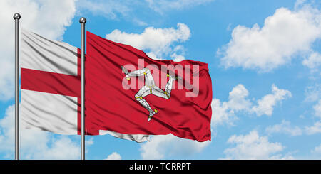 L'Angleterre et de brandir le drapeau de l'île de Man dans le vent contre ciel bleu nuageux blanc ensemble. Concept de diplomatie, de relations internationales. Banque D'Images