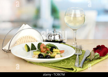 Bol à salade d'savoureux sur la table en bois sur fond de restaurant Banque D'Images