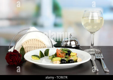 Bol à salade d'savoureux sur la table en bois sur fond de restaurant Banque D'Images