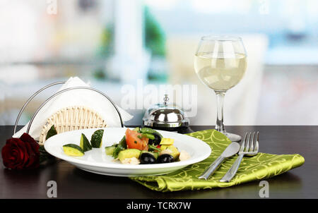 Bol à salade d'savoureux sur la table en bois sur fond de restaurant Banque D'Images