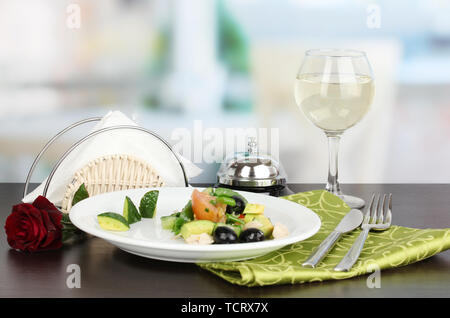 Bol à salade d'savoureux sur la table en bois sur fond de restaurant Banque D'Images