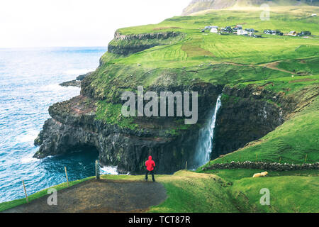 Tourist examine les Mulafossur Gasadalur sur chute près de Îles Féroé Banque D'Images